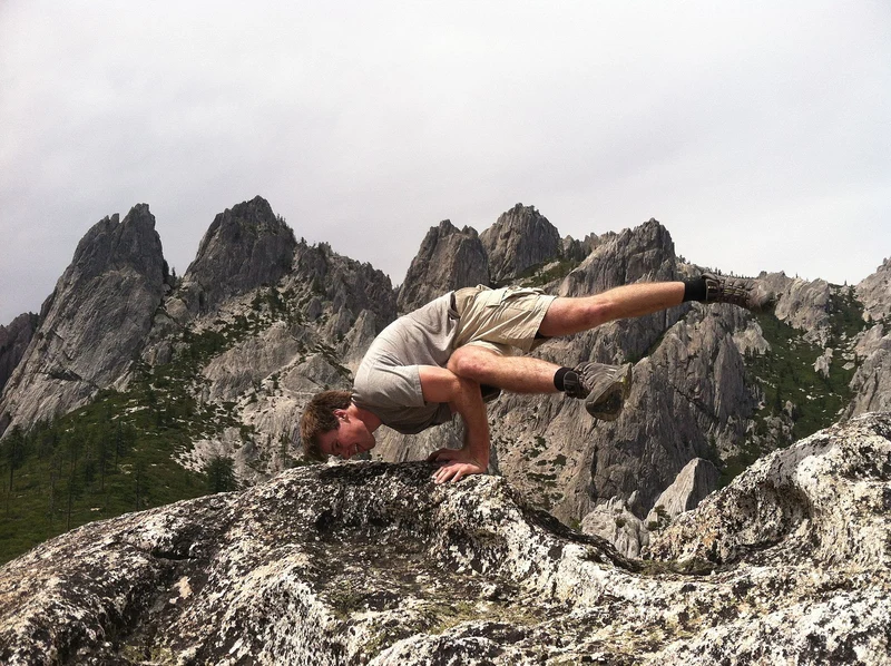 Yoga-Übung im Wald — Balance-Pose auf einem Felsen zwischen Bäumen
